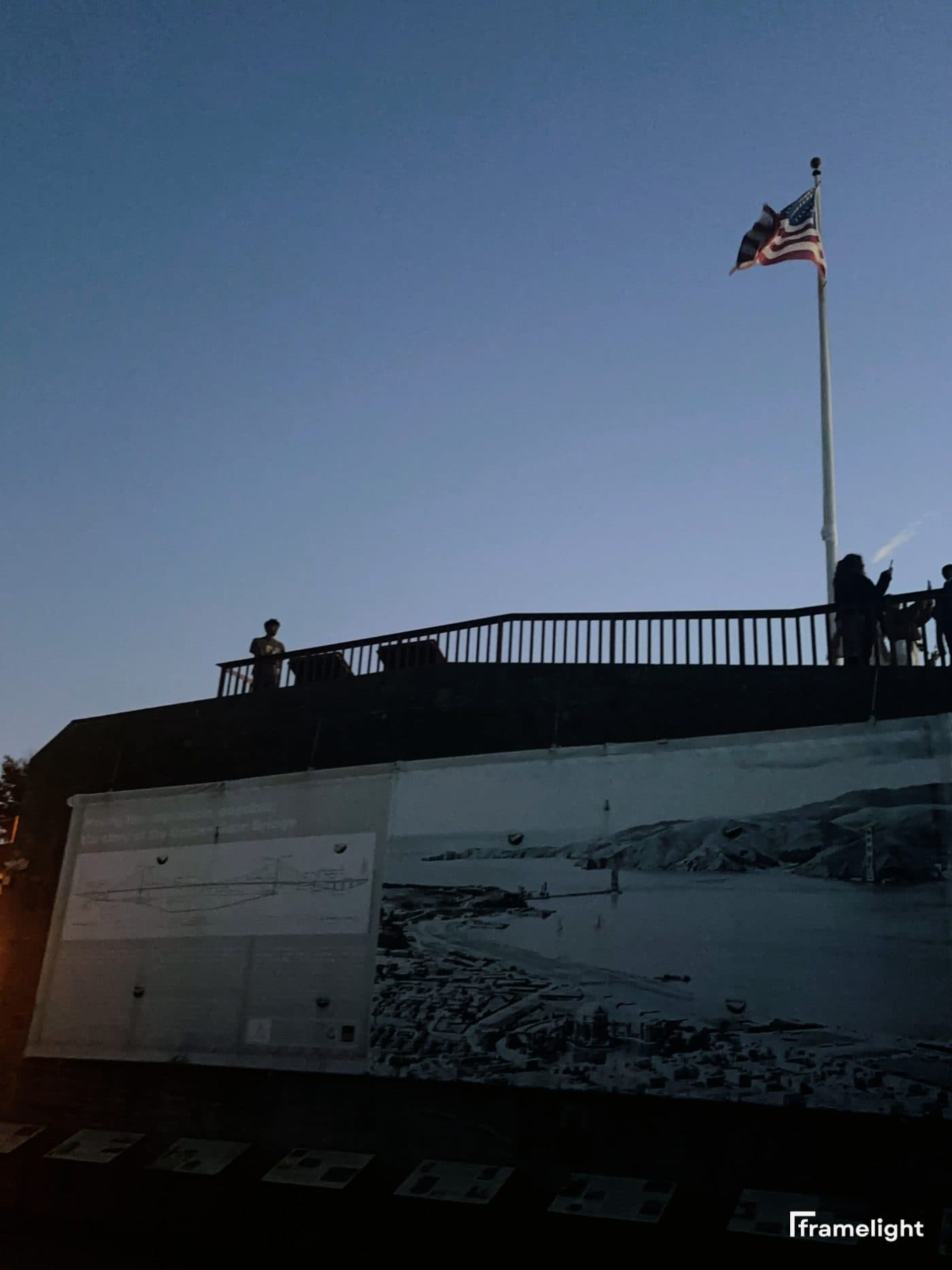 American flag at dusk above a historic Golden Gate Bridge mural — shot on Framelight